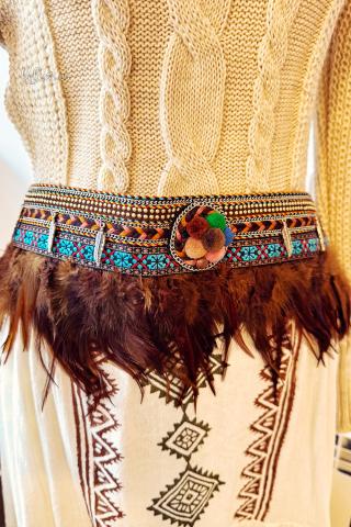 Ceinture bohème avec des plumes et des pompons.